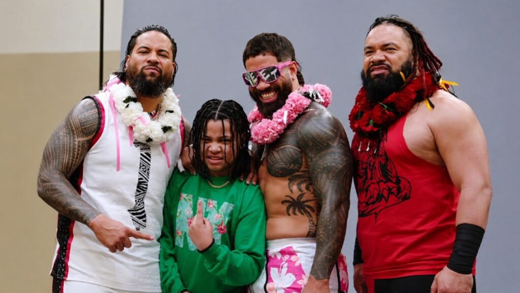 Jacob Fatu posing with Jey Uso, Jimmy Uso, and a young family member in a group photo showcasing the famous Anoaʻi wrestling family.