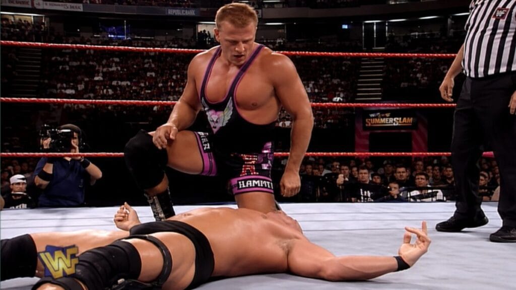 Owen Hart stands over Stone Cold Steve Austin during their match at SummerSlam 1997 in WWE.