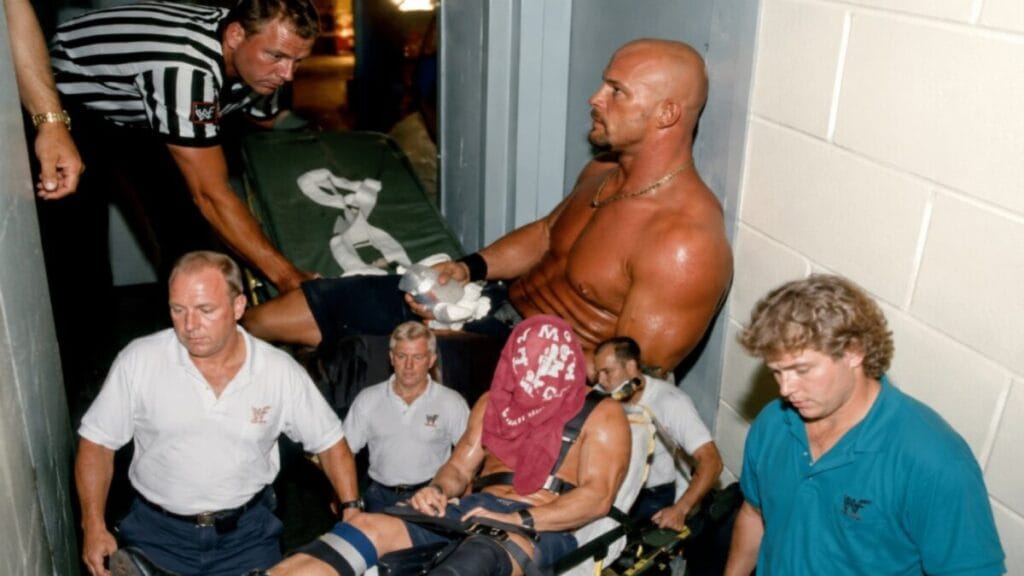 Stone Cold Steve Austin receives medical attention backstage after a serious neck injury during a WWE event in 1997.