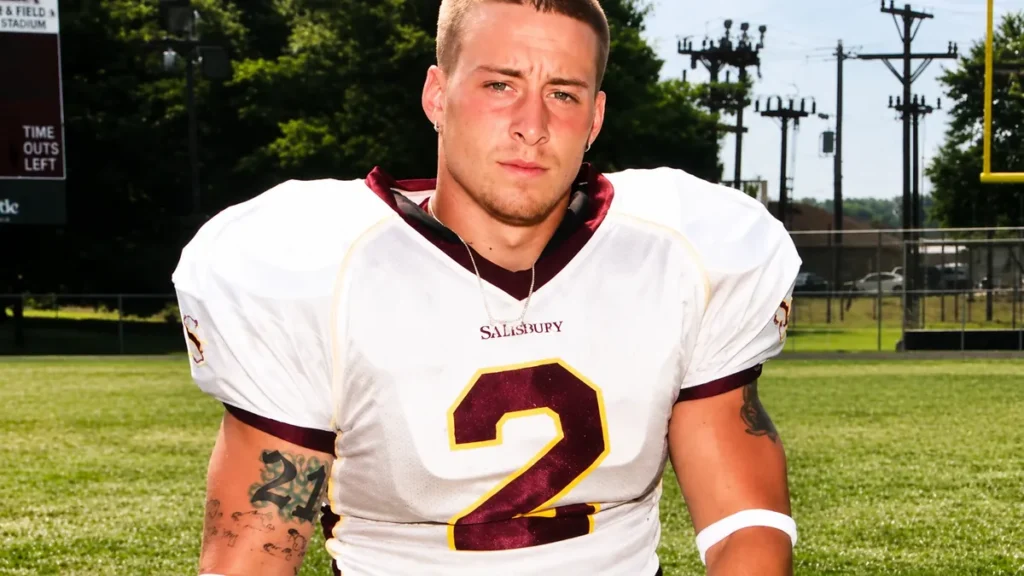 Young Enzo Amore during his football playing days, posing in uniform on a football field before his professional wrestling career.