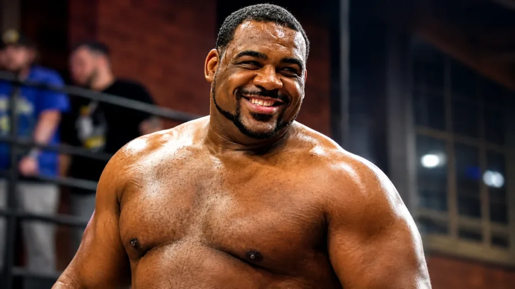 Close-up of Keith Lee smiling during a wrestling event before his WWE and AEW career highlights.